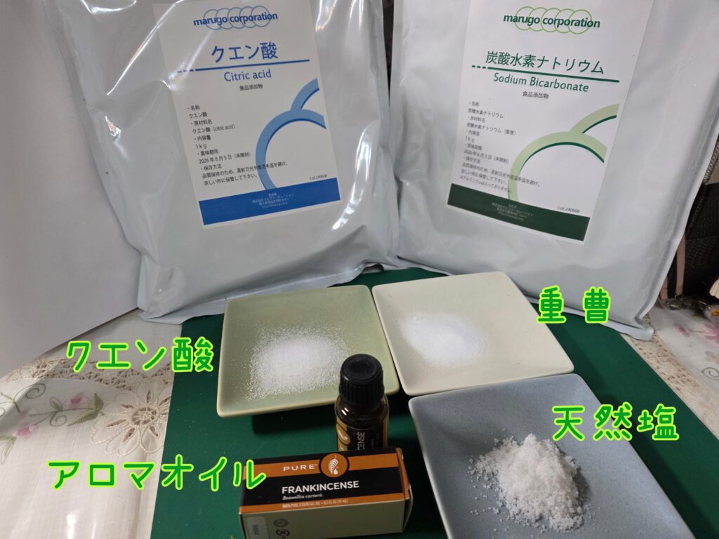 クエン酸、重曹、天然塩、アロマオイルを並べた写真。バスボムやバスソルト作りに使う基本材料のイメージ